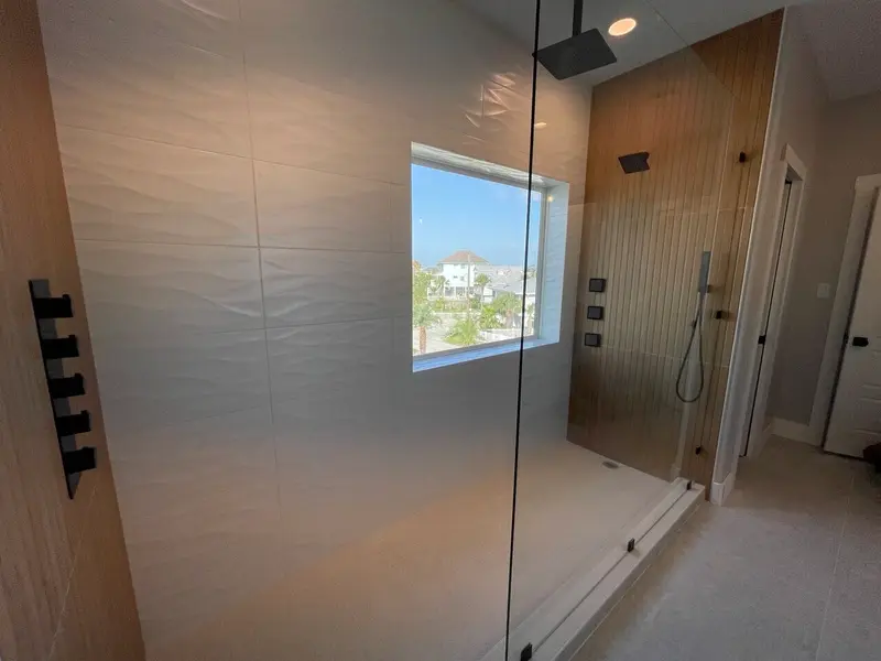 Large walk-in shower with picture window and wall-mounted shower jets