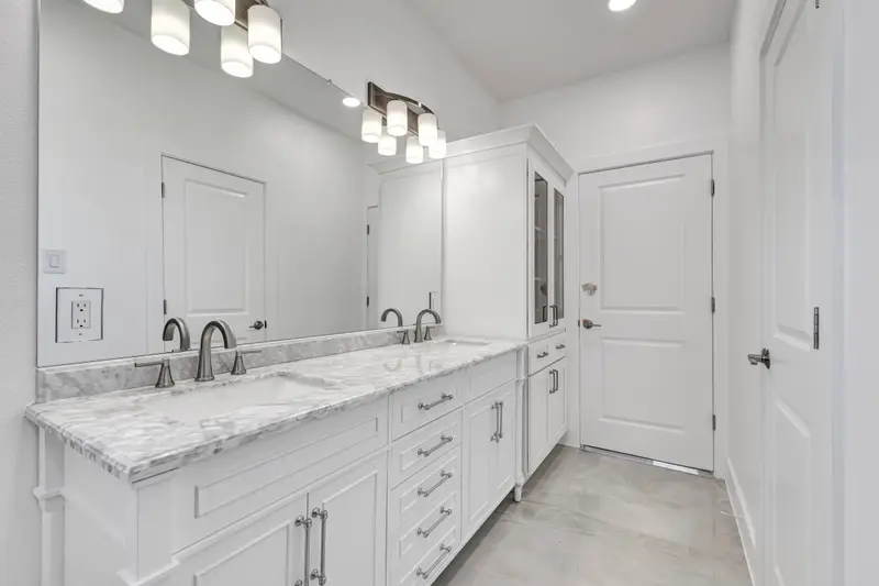 White double vanity with marble-look countertop in a remodeled bathroom