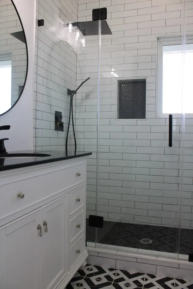 White subway tile shower with recessed niche and matte black fixtures