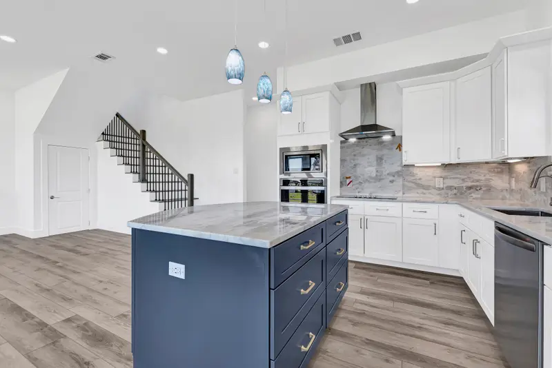 Navy kitchen island with marble-look quartz countertop and white shaker cabinetry