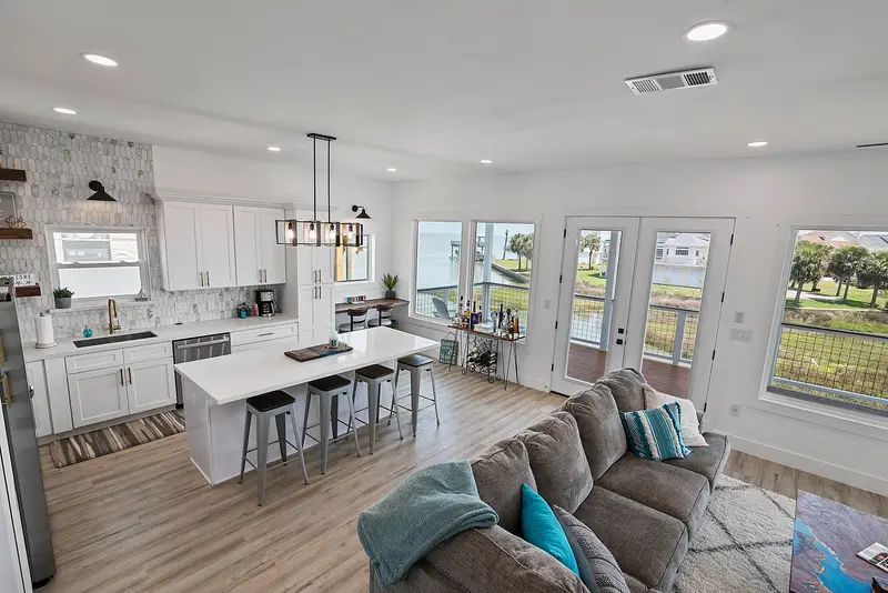 Open-concept kitchen and living room with white island and quartz countertops